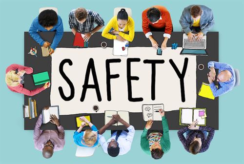 Image of People around a table with Safety written in the middle